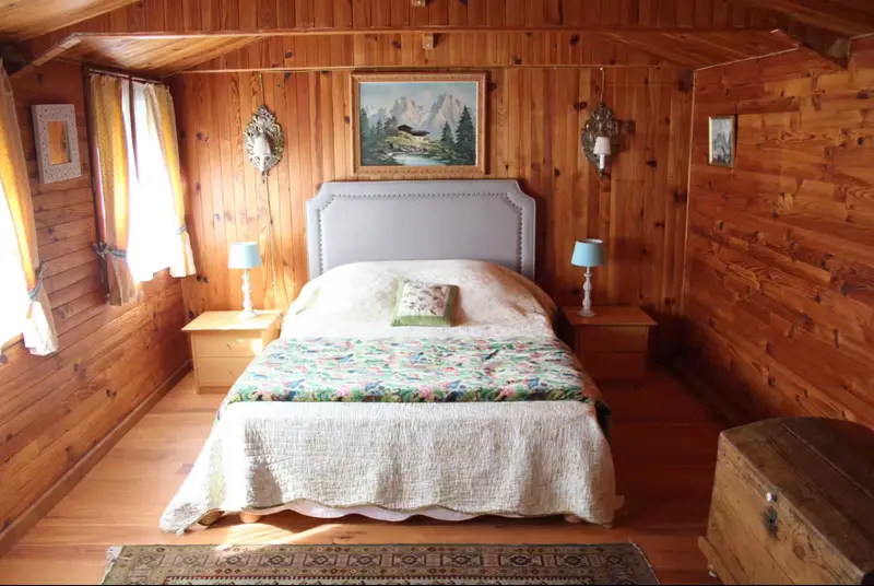 Chambre lambrissée avec lit double et tête de lit capitonnée