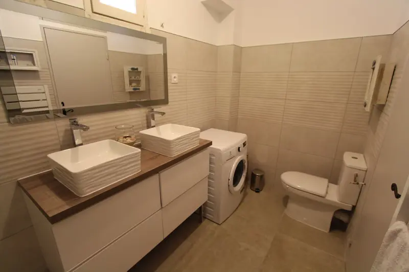 Salle de bain avec lave-linge et double vasque