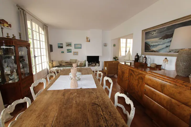 Salle à manger lumineuse avec cheminée et tableau représentant la mer